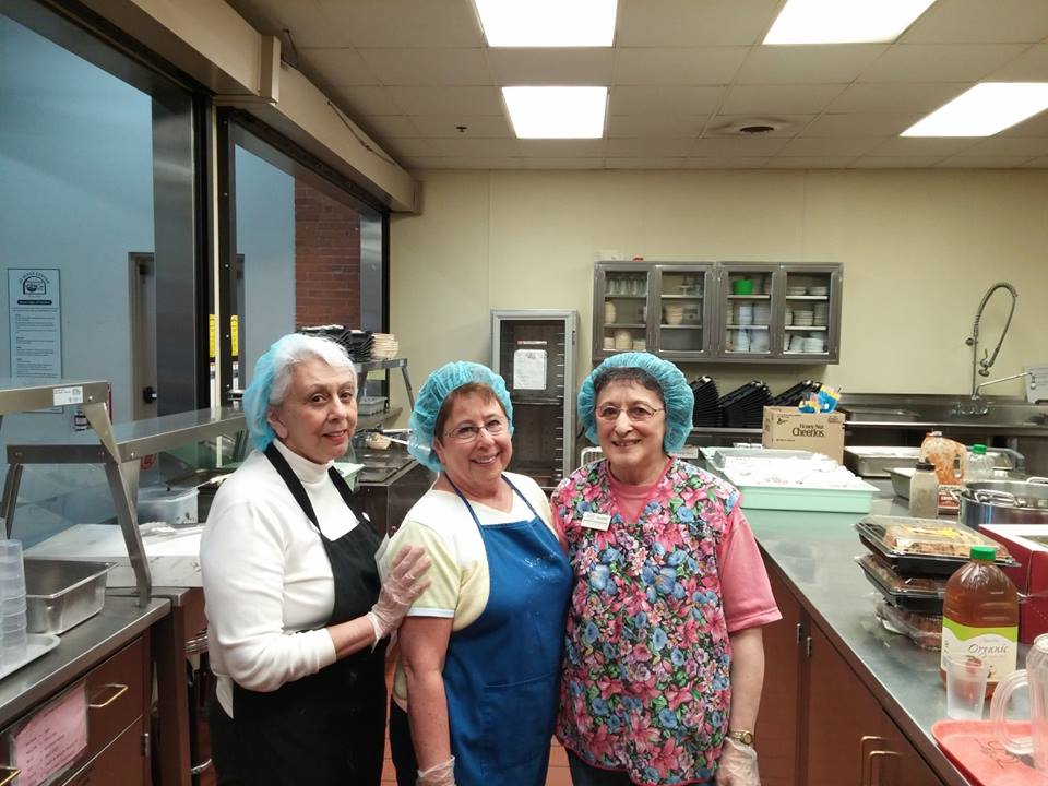 three women volunteers in the kitchen