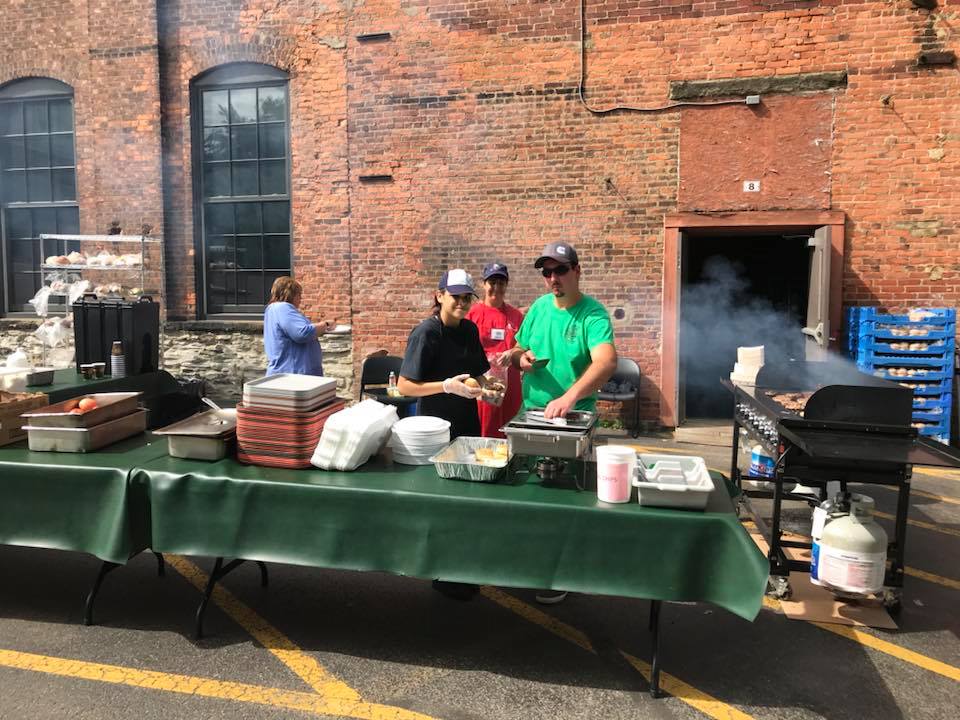 volunteers serving burgers outside on the grill